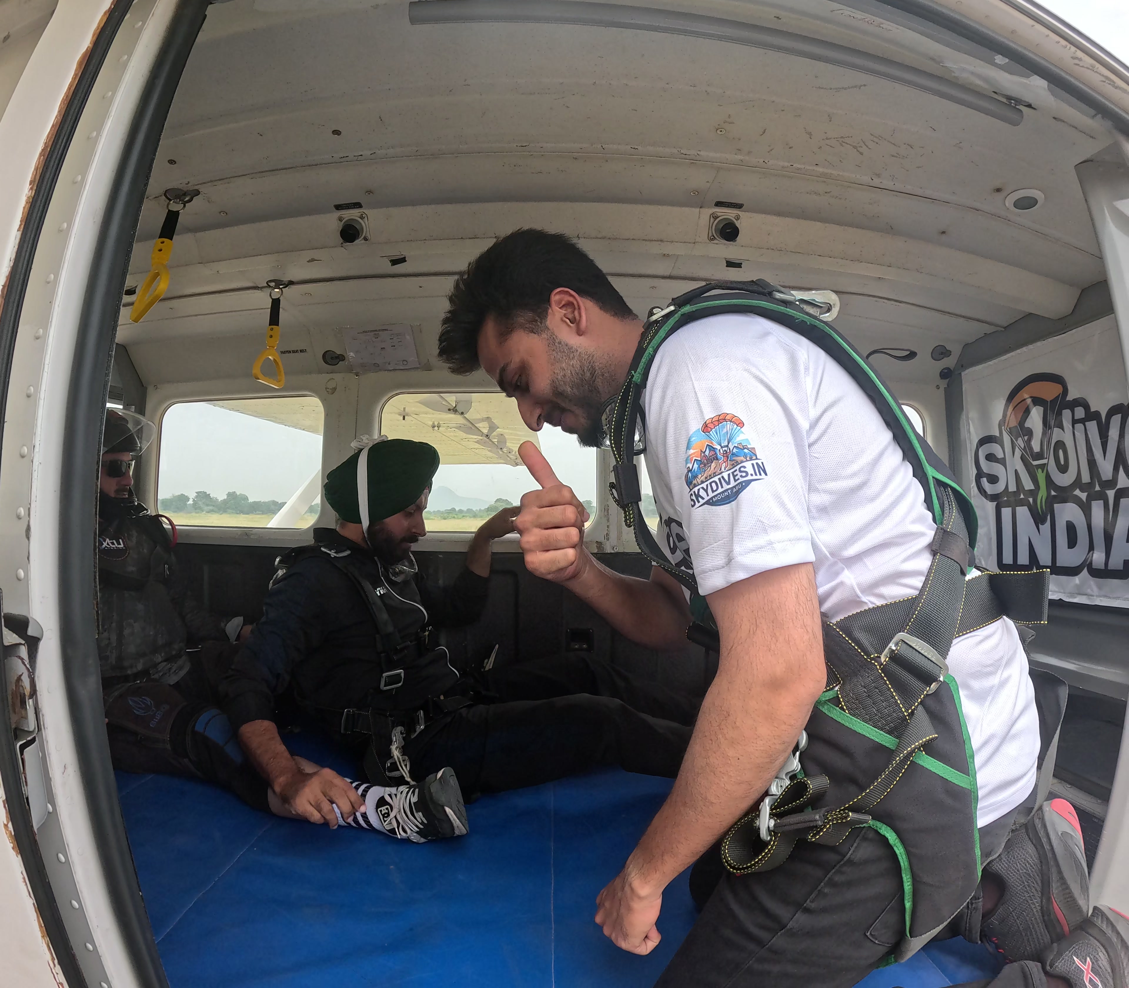 Instructor giving a thumbs-up to a seated customer inside the Skydive India plane