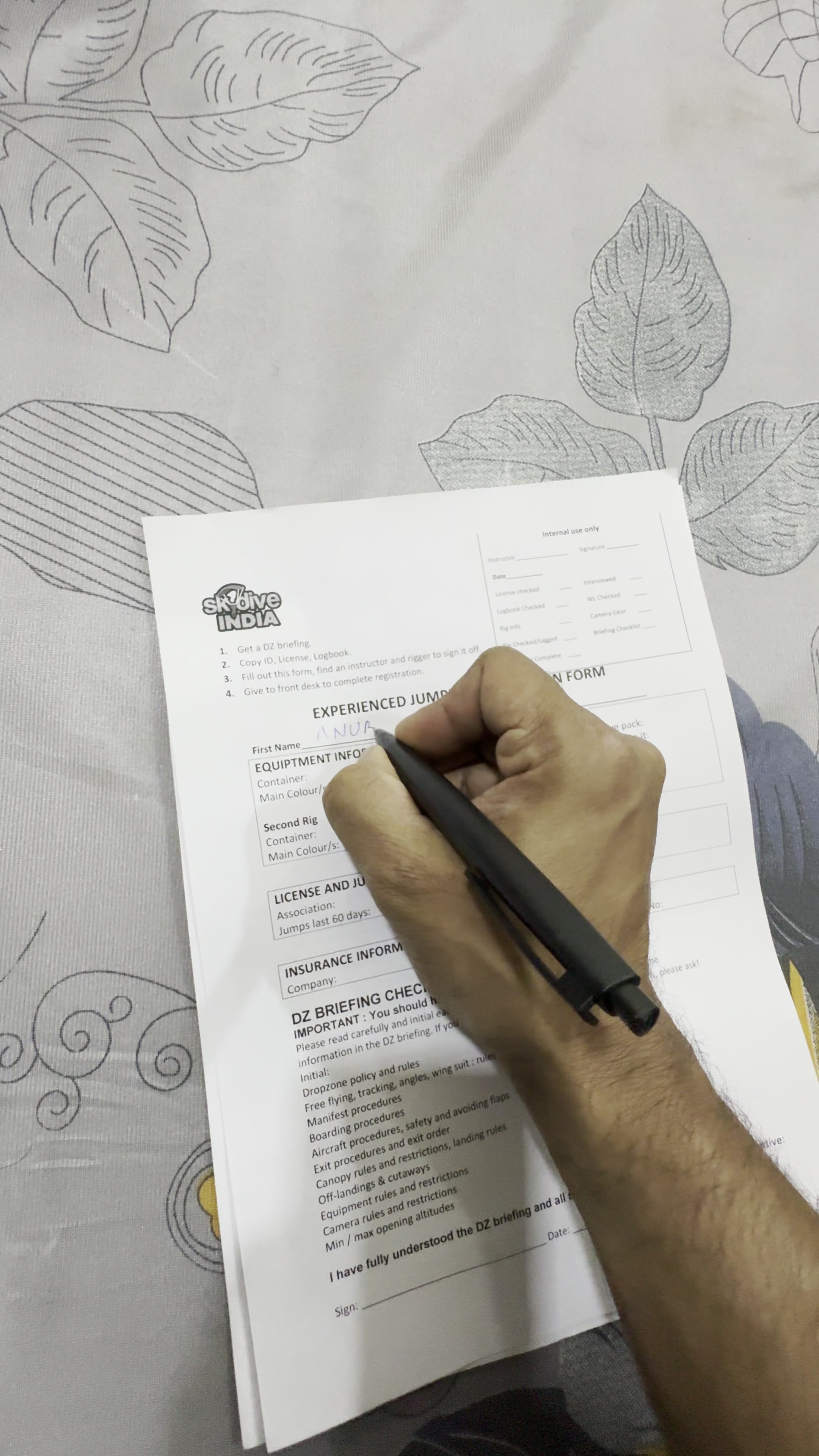 Hand signing a Skydive India waiver form
