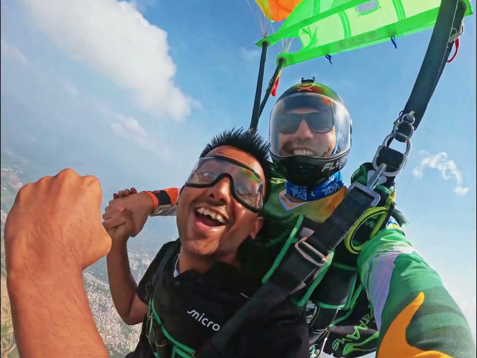 Tandem pair flying under the parachute above Mount Abu