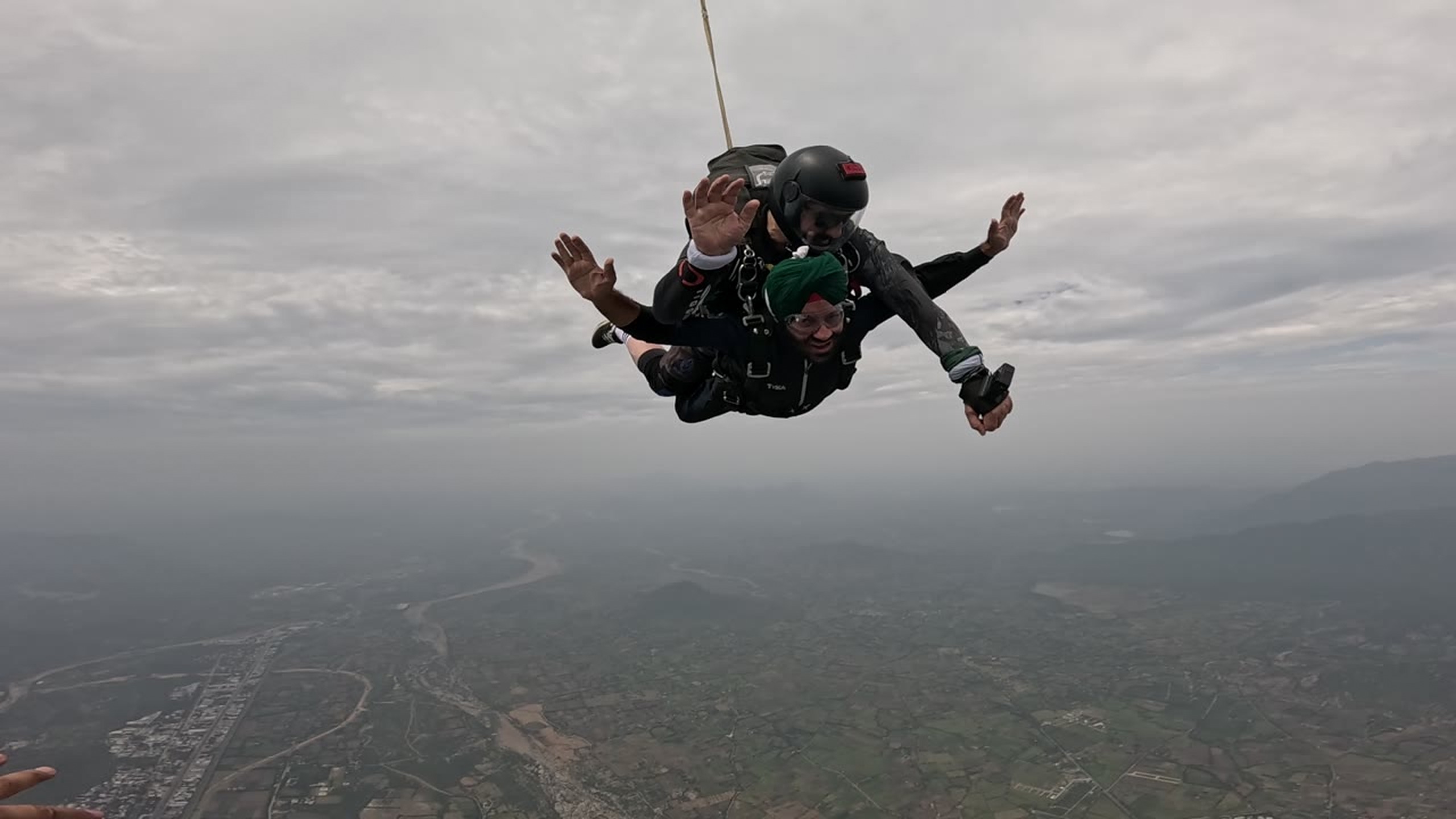Tandem passenger and instructor centered in freefall above Mount Abu